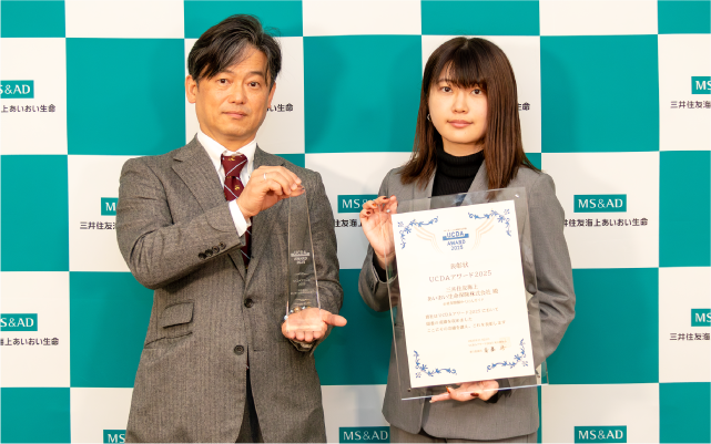 アワード受賞のトロフィーと表彰状をもったお二人の写真